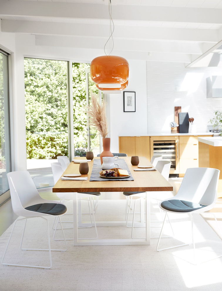 Foto di una sala da pranzo aperta verso la cucina moderna di medie dimensioni con pareti bianche e nessun camino