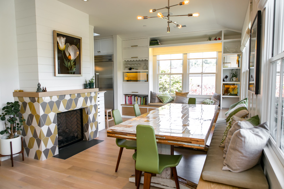Example of a transitional medium tone wood floor and brown floor kitchen/dining room combo design in San Francisco with white walls, a standard fireplace and a tile fireplace