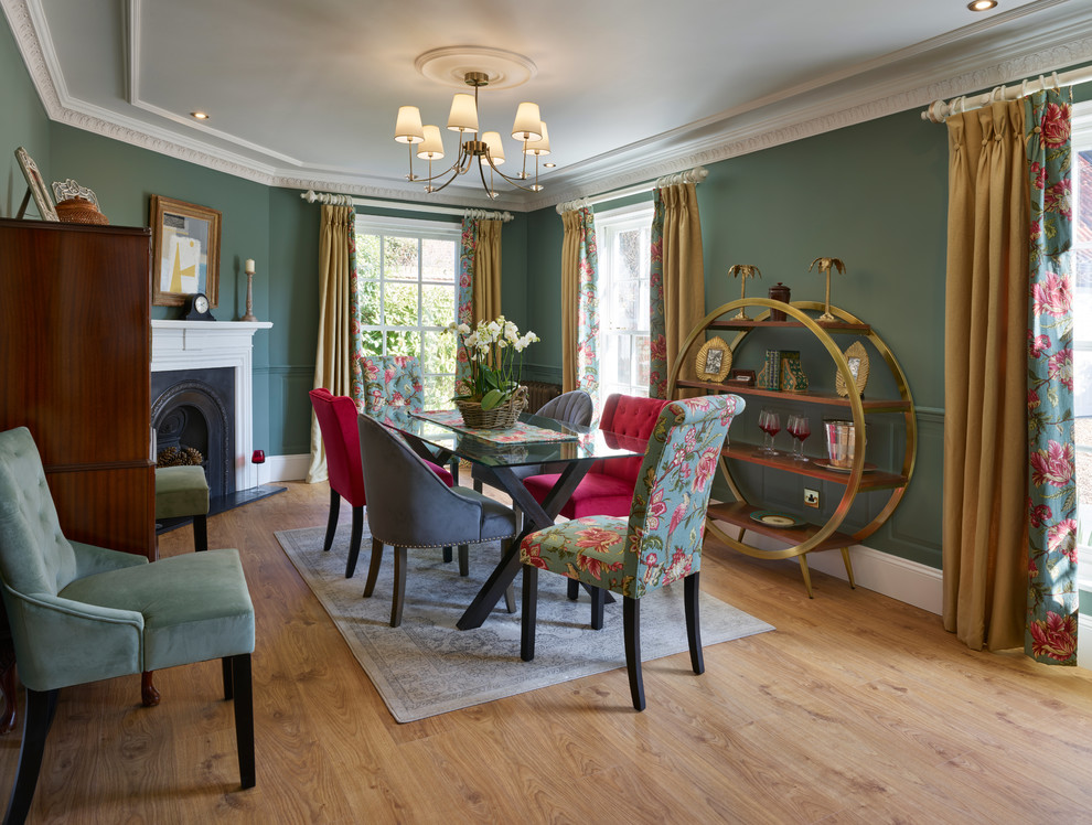 Geschlossenes, Mittelgroßes Klassisches Esszimmer mit grüner Wandfarbe, braunem Holzboden, Eckkamin und braunem Boden in Sonstige