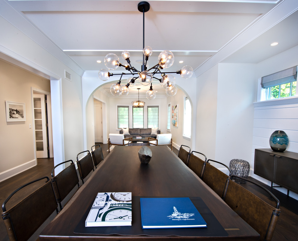 Immagine di una grande sala da pranzo aperta verso la cucina contemporanea con pareti bianche, pavimento in legno verniciato, pavimento marrone e pareti in perlinato
