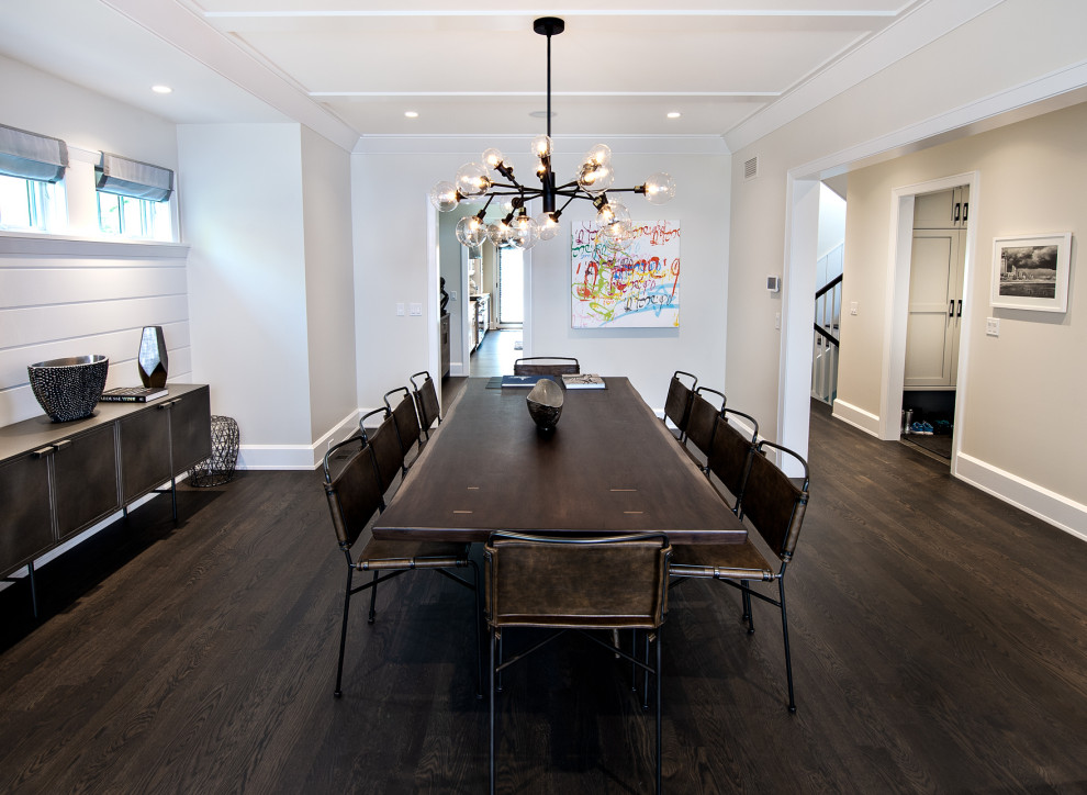 Cette image montre une grande salle à manger ouverte sur la cuisine design avec un mur blanc, parquet peint, un sol marron et du lambris de bois.