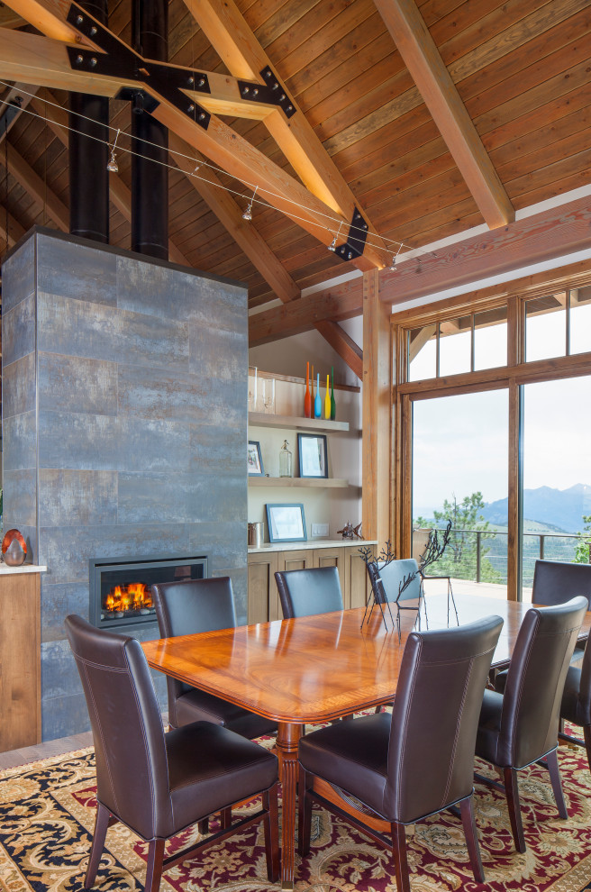 Inspiration for a rustic dining room in Denver with a ribbon fireplace, a metal fireplace surround, exposed beams, a vaulted ceiling, a wood ceiling and a chimney breast.