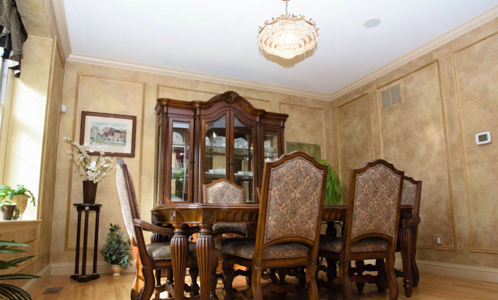 Cette image montre une salle à manger traditionnelle fermée et de taille moyenne avec un mur beige, parquet clair, aucune cheminée et un sol beige.