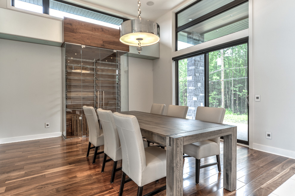 Large modern open plan dining room in Montreal with white walls and medium hardwood flooring.