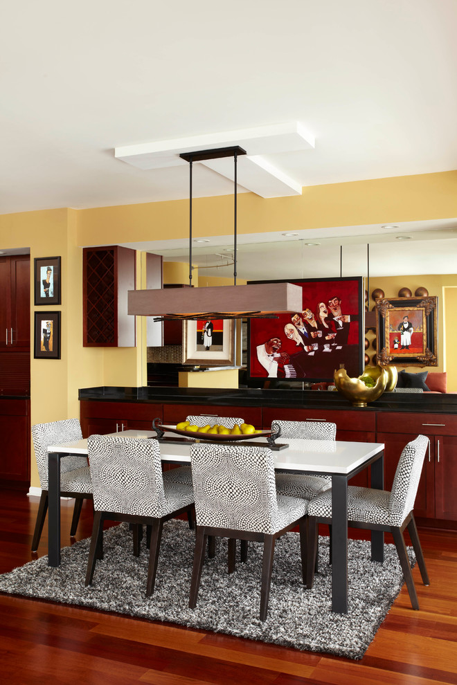 Réalisation d'une salle à manger ouverte sur le salon design de taille moyenne avec un mur jaune et un sol en bois brun.