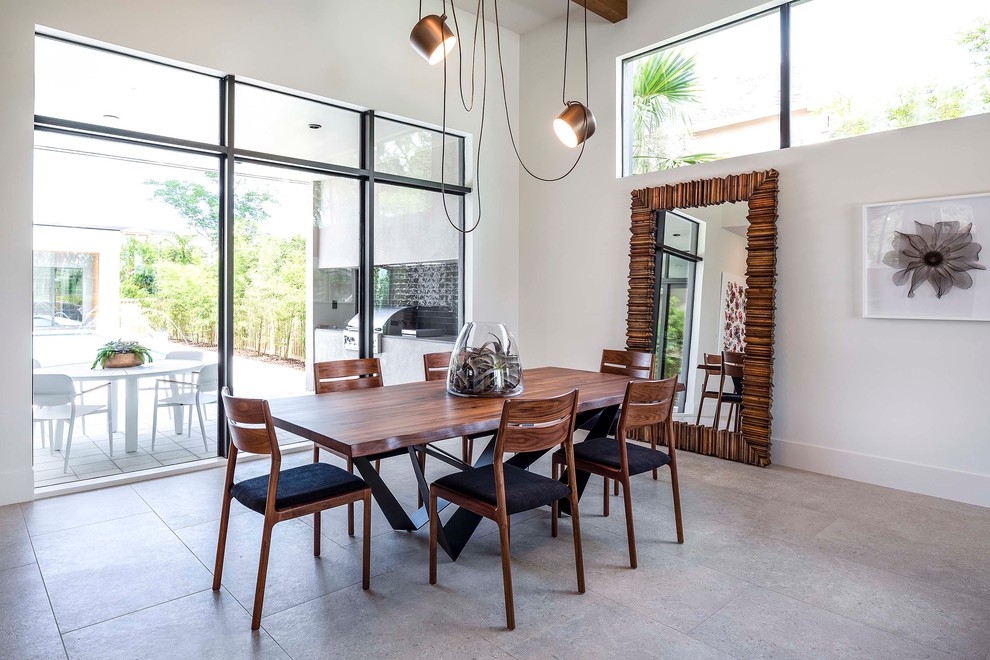 Esempio di una grande sala da pranzo aperta verso la cucina contemporanea con pareti bianche, pavimento con piastrelle in ceramica e pavimento grigio