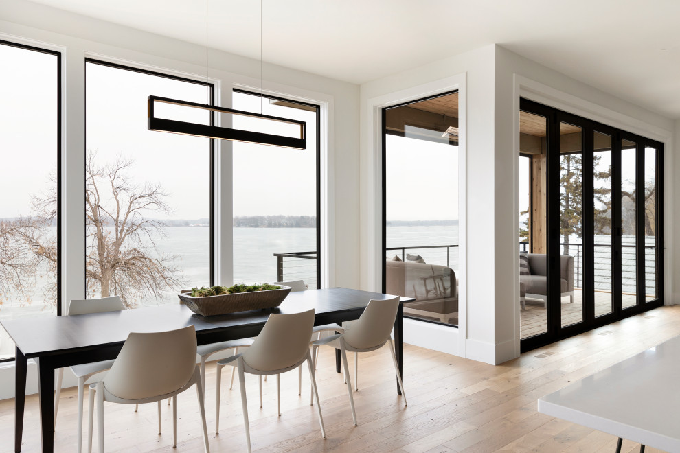 Idée de décoration pour une salle à manger design avec un mur blanc, un sol en bois brun et un sol marron.