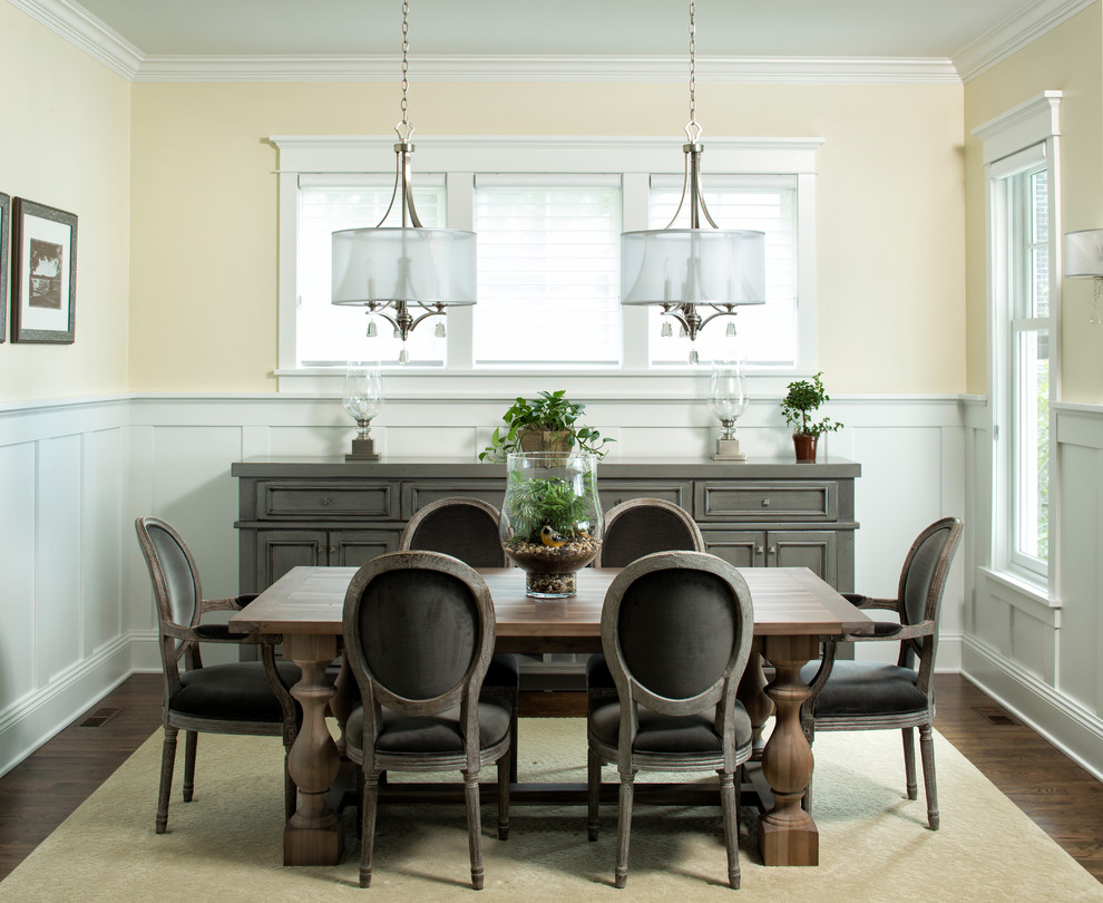 Traditional dining room in Minneapolis with yellow walls and dark hardwood flooring.