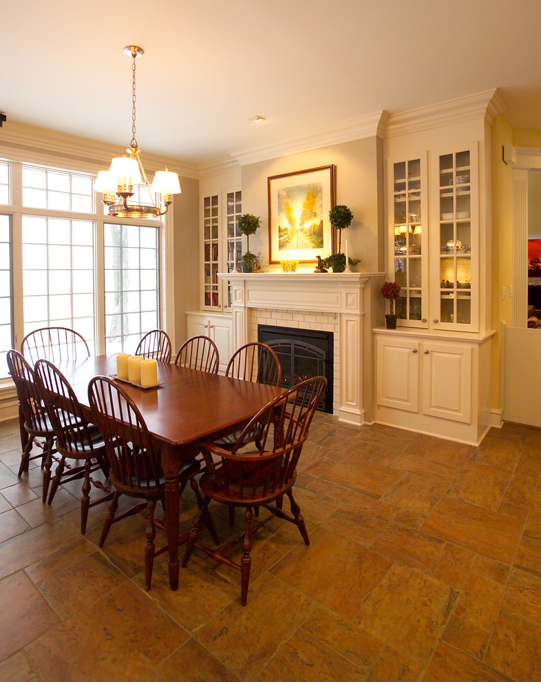 Cette photo montre une salle à manger ouverte sur la cuisine chic de taille moyenne avec un mur beige, tomettes au sol et une cheminée standard.