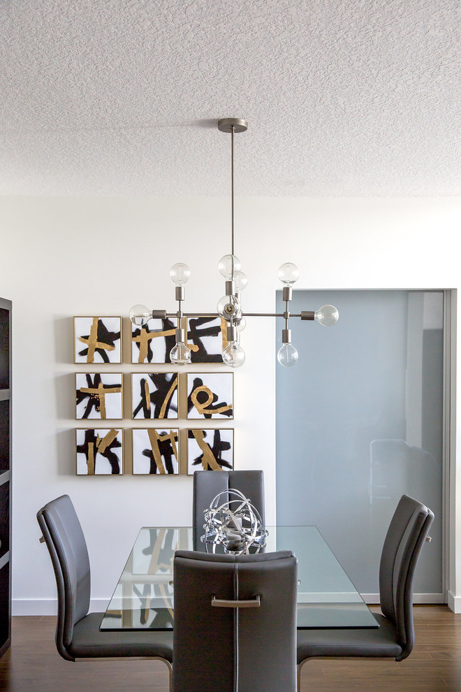 This is an example of a small modern kitchen/dining room in Calgary with white walls, laminate floors and brown floors.