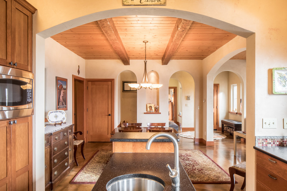 Inspiration pour une salle à manger ouverte sur la cuisine méditerranéenne de taille moyenne avec un mur orange, sol en béton ciré, une cheminée standard, un manteau de cheminée en carrelage et un sol marron.