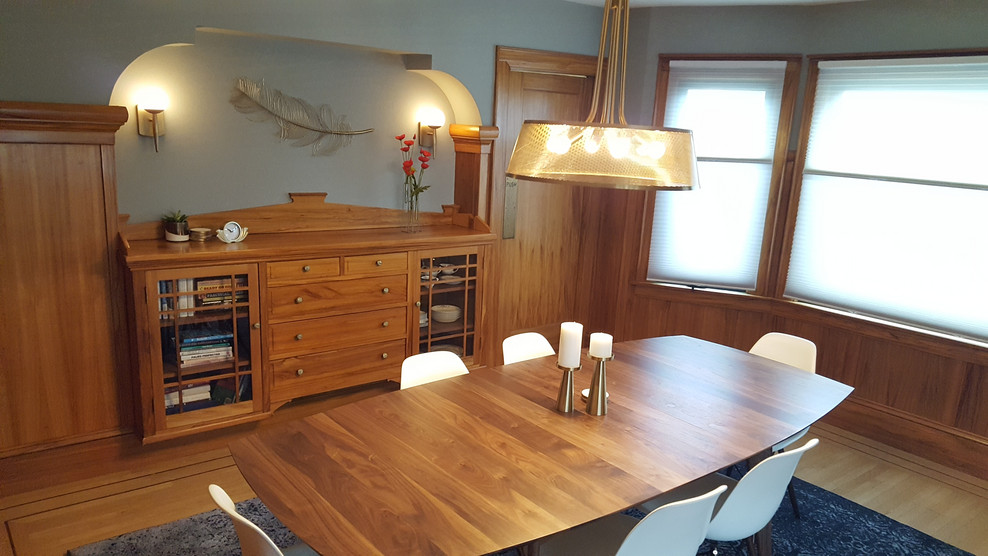 Cette image montre une salle à manger vintage fermée et de taille moyenne avec un mur gris, un sol en bois brun et un sol marron.