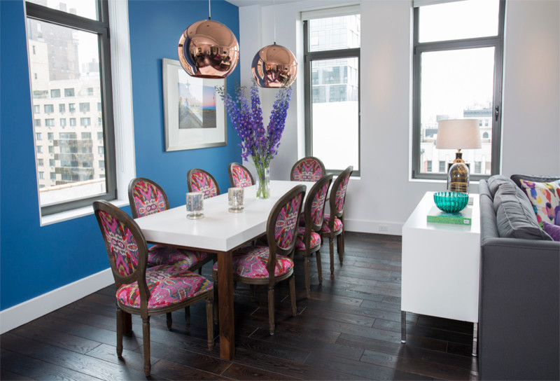 Idée de décoration pour une salle à manger ouverte sur le salon minimaliste de taille moyenne avec un mur bleu, parquet foncé, aucune cheminée et un sol marron.