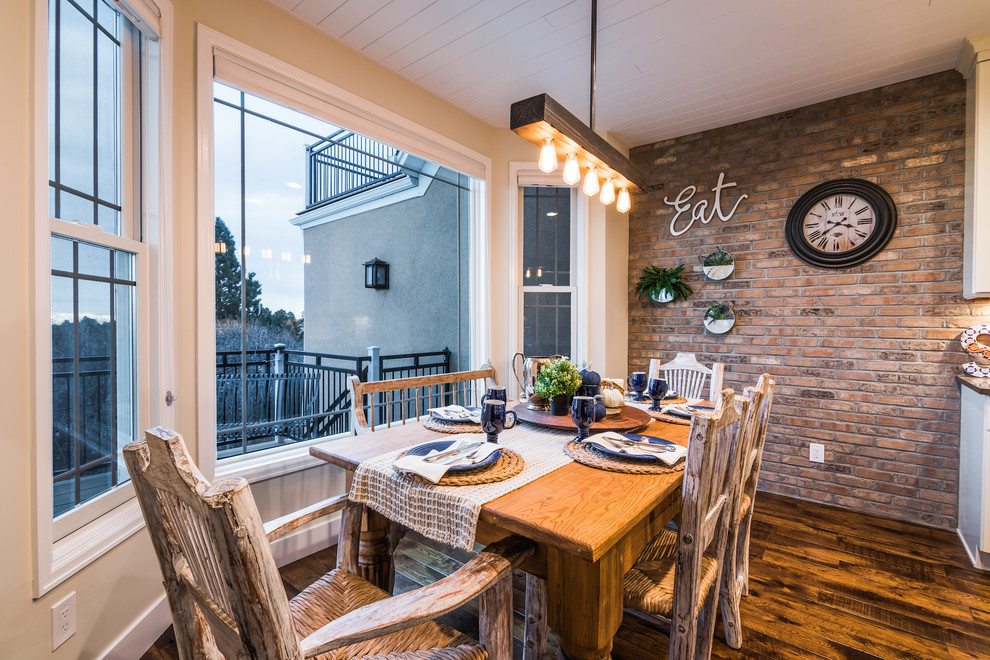 Esempio di una sala da pranzo aperta verso la cucina country di medie dimensioni con pavimento in legno massello medio, pavimento marrone e pareti beige