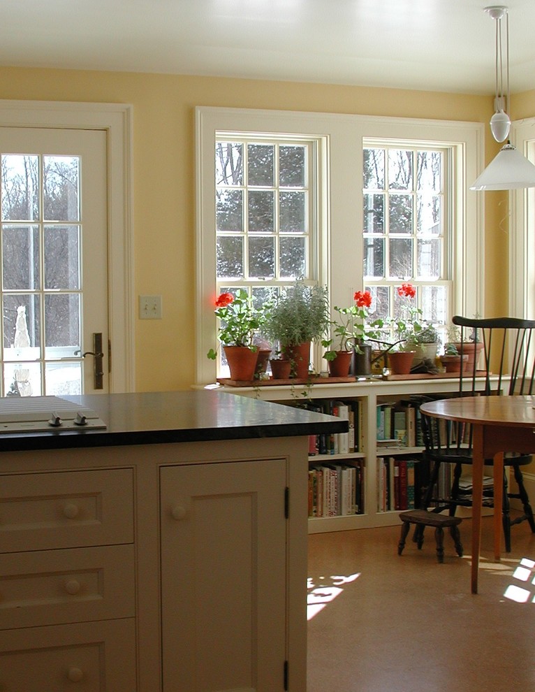 Ejemplo de comedor de cocina de estilo de casa de campo de tamaño medio sin chimenea con paredes amarillas, suelo laminado y suelo beige