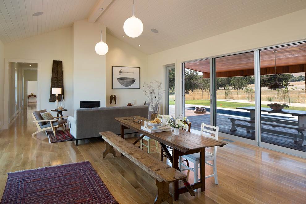 Offenes Landhaus Esszimmer mit gelber Wandfarbe, braunem Holzboden und braunem Boden in San Francisco
