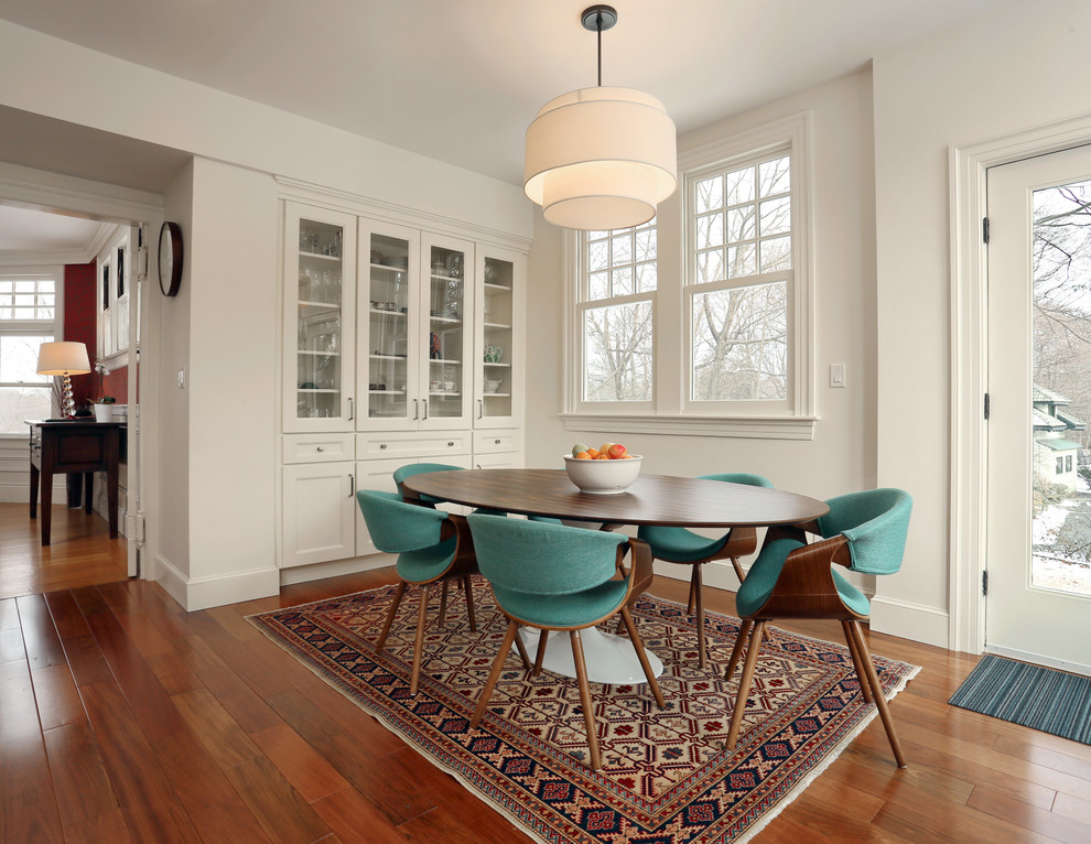 This is an example of a medium sized traditional dining room in Boston with laminate floors, brown floors and white walls.