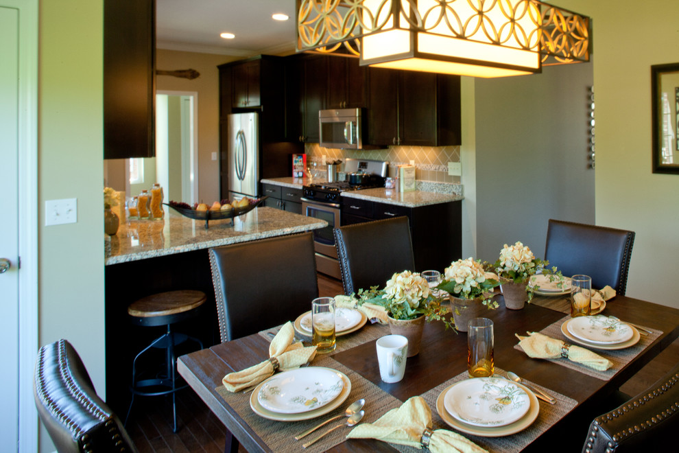 Inspiration pour une grande salle à manger ouverte sur la cuisine design avec un mur vert et un sol en bois brun.