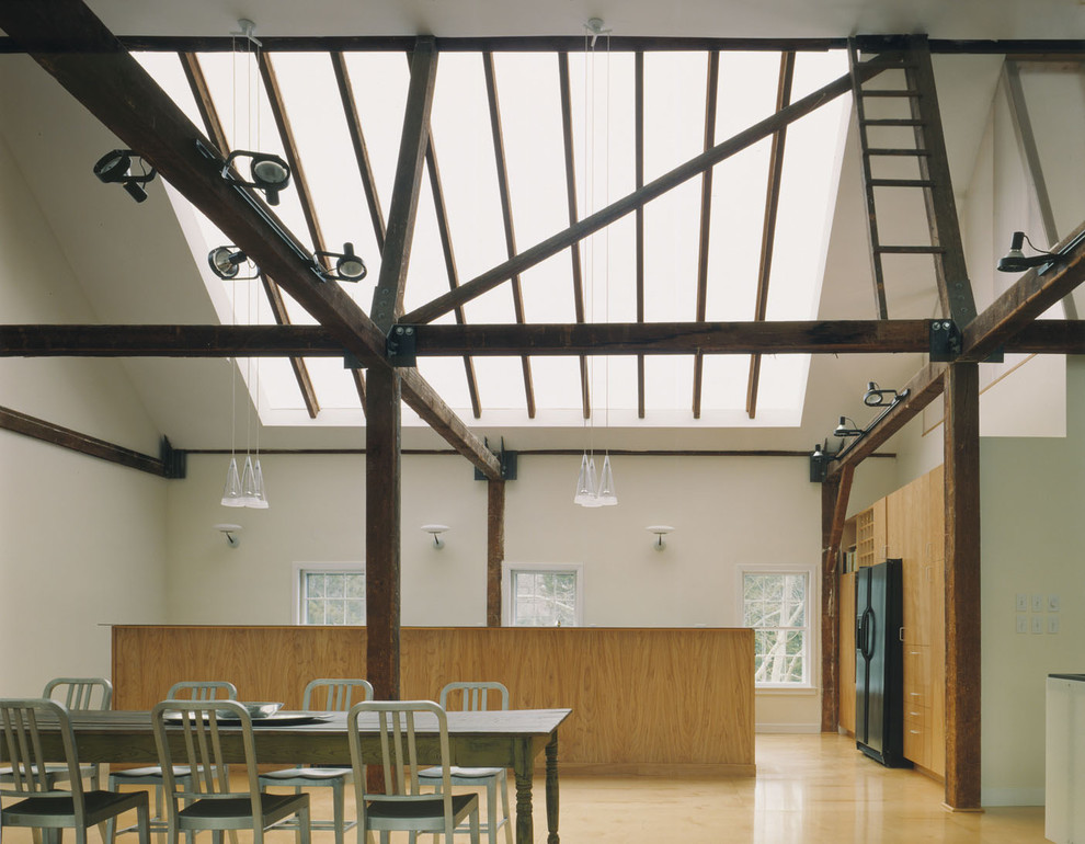 Cette photo montre une salle à manger industrielle avec un mur blanc et un sol en bois brun.
