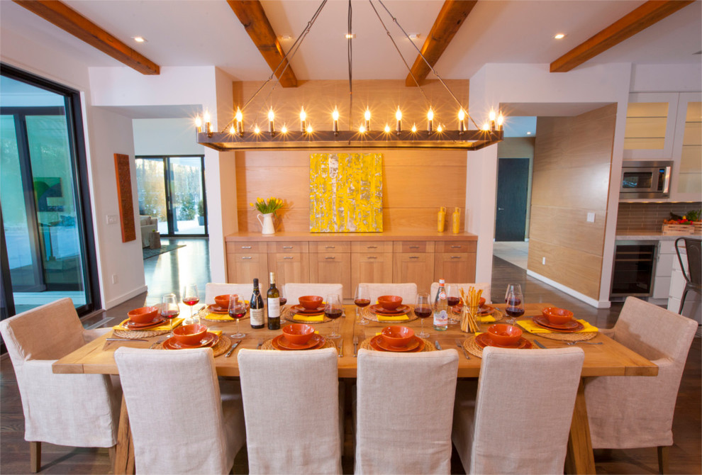 Cette photo montre une grande salle à manger ouverte sur la cuisine nature avec parquet foncé.