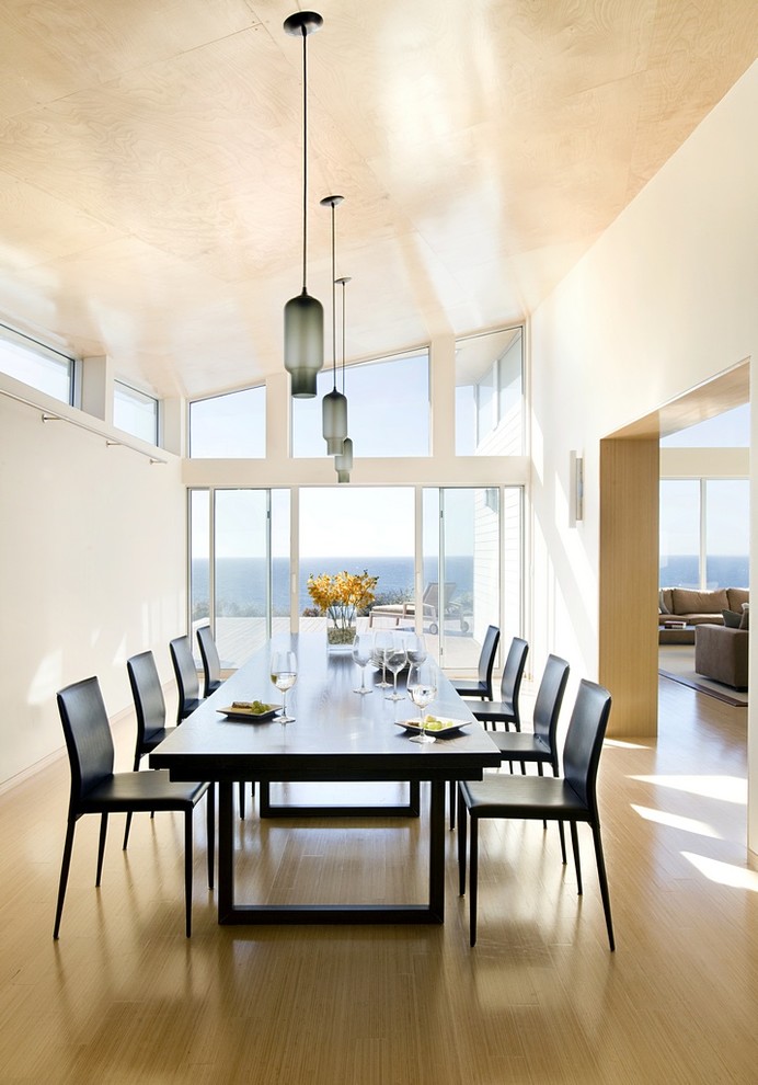 На фото: столовая в стиле модернизм с белыми стенами и паркетным полом среднего тона