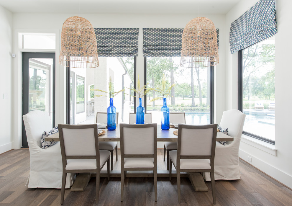 Beach style dining room in Houston with white walls, dark hardwood flooring and brown floors.