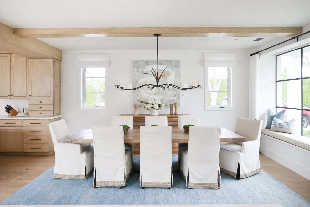 Immagine di una sala da pranzo costiera con pareti bianche, parquet chiaro e pavimento beige