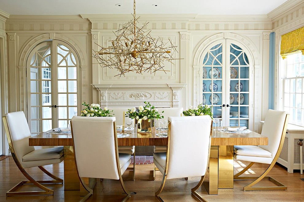 Idee per una sala da pranzo classica chiusa con pareti blu, camino classico e pavimento in legno massello medio