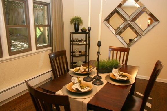 Inspiration pour une salle à manger ouverte sur le salon minimaliste de taille moyenne avec un mur orange, un sol en bois brun et aucune cheminée.