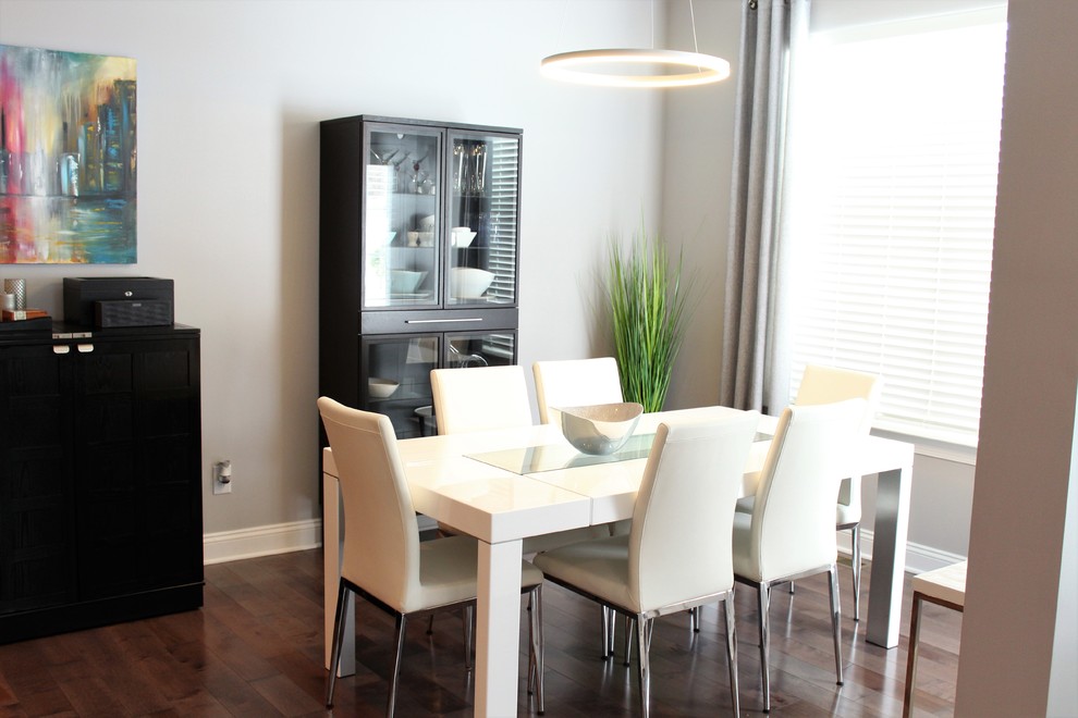Esempio di una sala da pranzo aperta verso la cucina minimalista di medie dimensioni con pareti grigie, pavimento in legno massello medio e nessun camino