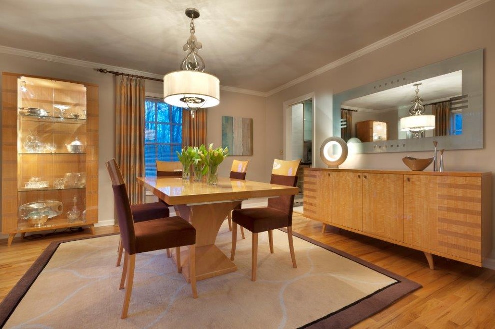 Design ideas for a large modern enclosed dining room in New York with beige walls and light hardwood flooring.