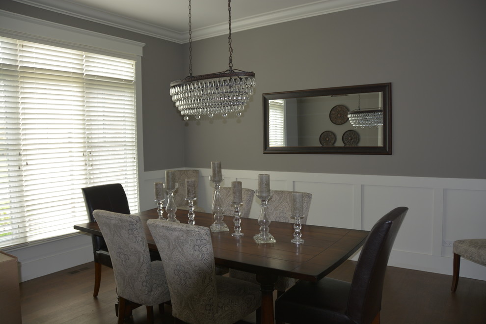 Exemple d'une salle à manger ouverte sur le salon chic de taille moyenne avec un mur gris, parquet foncé, aucune cheminée et un sol marron.