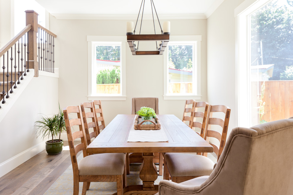 Idée de décoration pour une salle à manger ouverte sur le salon champêtre de taille moyenne avec un mur gris, un sol en bois brun, aucune cheminée et un sol marron.