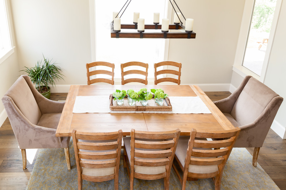 Aménagement d'une salle à manger ouverte sur le salon campagne de taille moyenne avec un mur gris, un sol en bois brun, aucune cheminée et un sol marron.