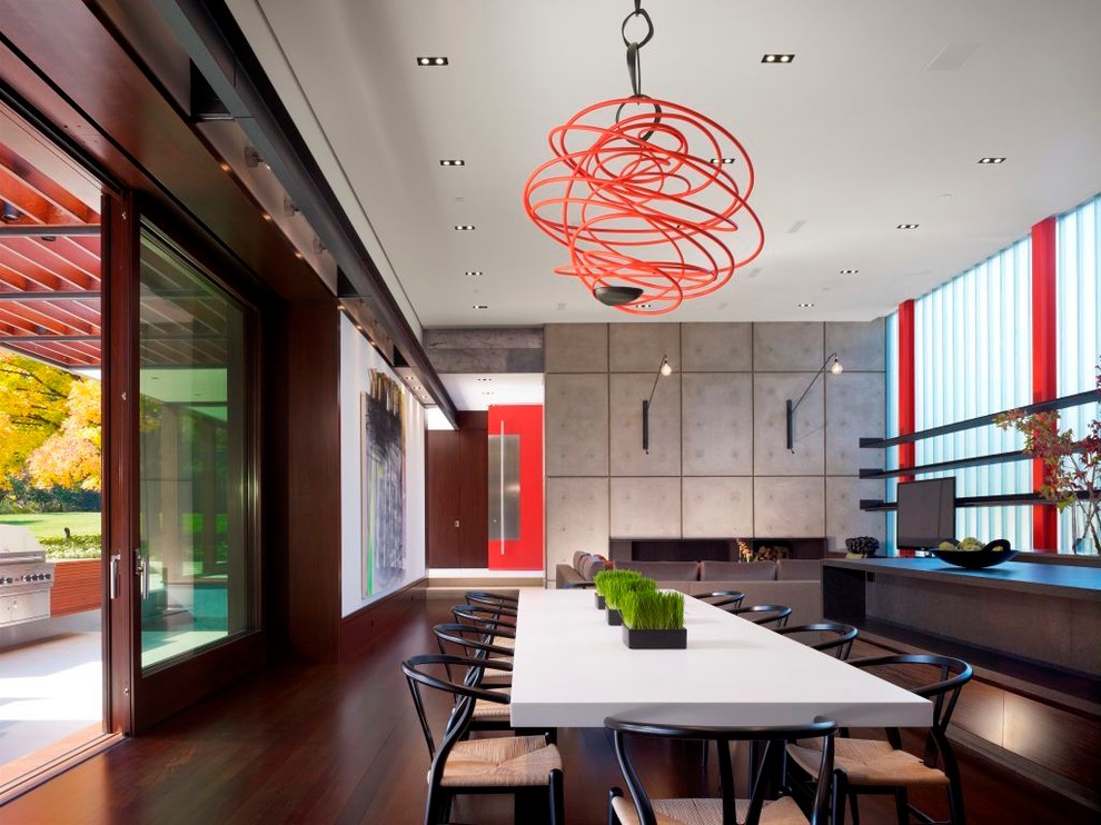 Exemple d'une salle à manger moderne avec parquet foncé et éclairage.
