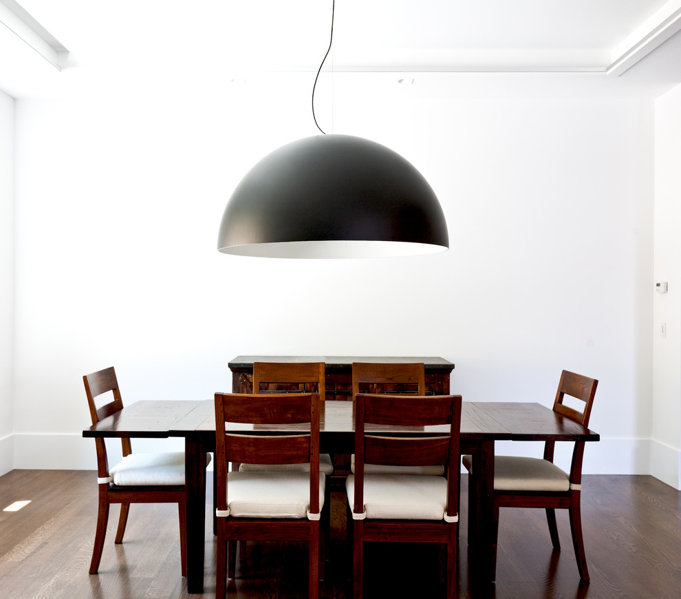 Ispirazione per una sala da pranzo aperta verso la cucina moderna di medie dimensioni con pareti bianche, parquet scuro e nessun camino