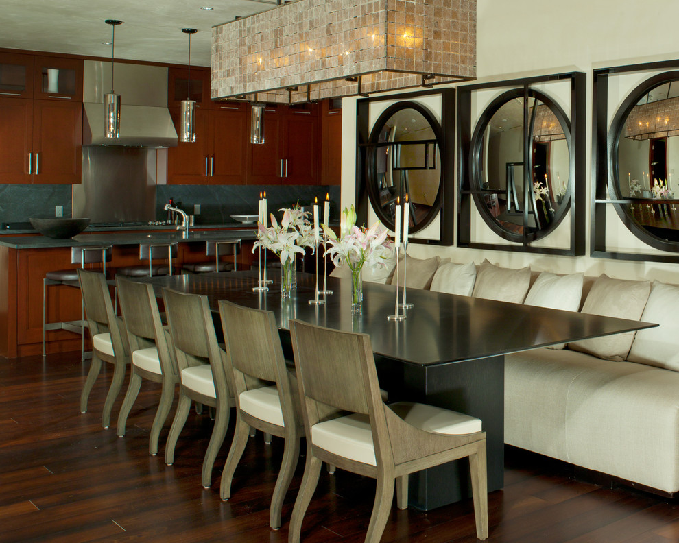 Immagine di una sala da pranzo aperta verso la cucina moderna con pareti bianche e parquet scuro