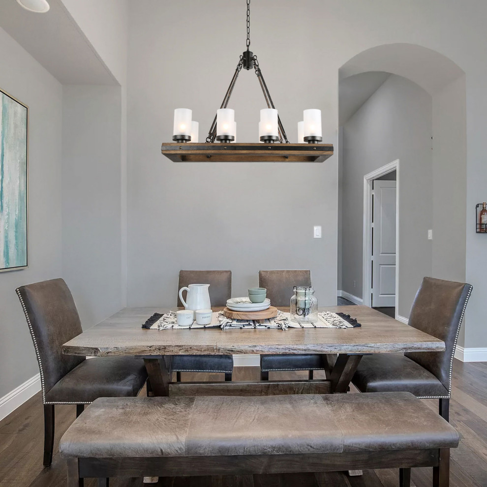 Cette photo montre une petite salle à manger ouverte sur la cuisine avec un mur gris, un sol en contreplaqué, une cheminée d'angle, un manteau de cheminée en brique et un sol marron.