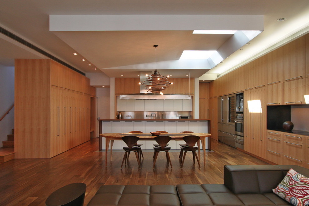 Moderne Wohnküche mit dunklem Holzboden in New York
