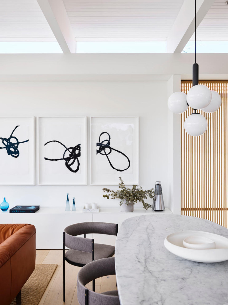 Стильный дизайн: гостиная-столовая в стиле модернизм с белыми стенами, светлым паркетным полом, бежевым полом и балками на потолке - последний тренд