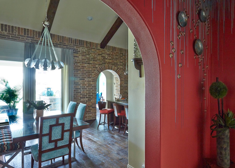 Idee per una sala da pranzo aperta verso la cucina tropicale di medie dimensioni con pareti rosse e parquet scuro