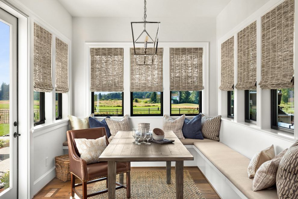 Immagine di una grande sala da pranzo aperta verso la cucina country con pavimento in legno massello medio, pavimento marrone e pareti bianche
