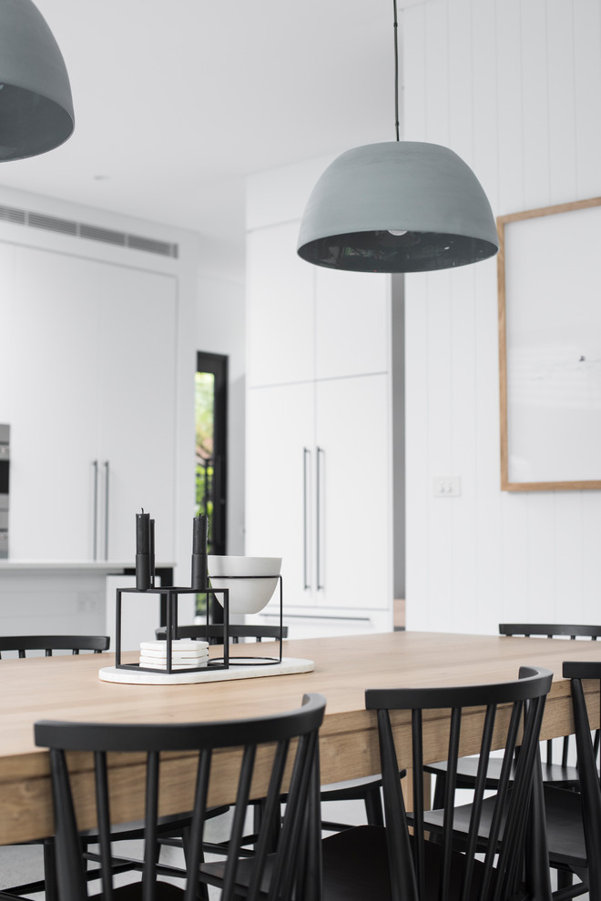 Ispirazione per una grande sala da pranzo aperta verso la cucina minimalista con pareti bianche, pavimento in cemento e pavimento grigio