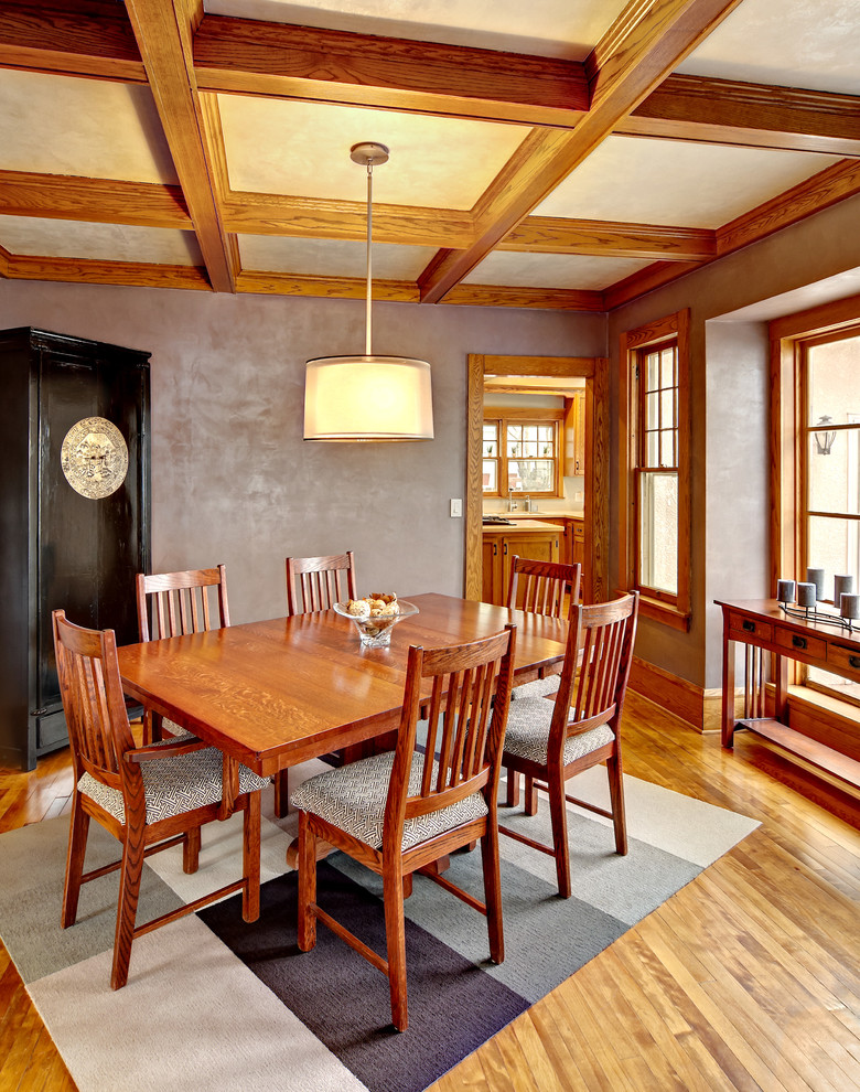 Cette photo montre une salle à manger tendance fermée et de taille moyenne avec un mur violet et un sol en bois brun.