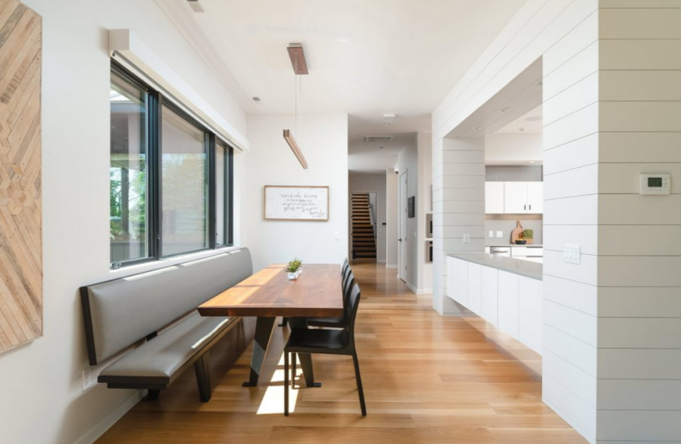 Imagen de comedor de cocina moderno de tamaño medio sin chimenea con paredes blancas, suelo de madera clara y suelo beige