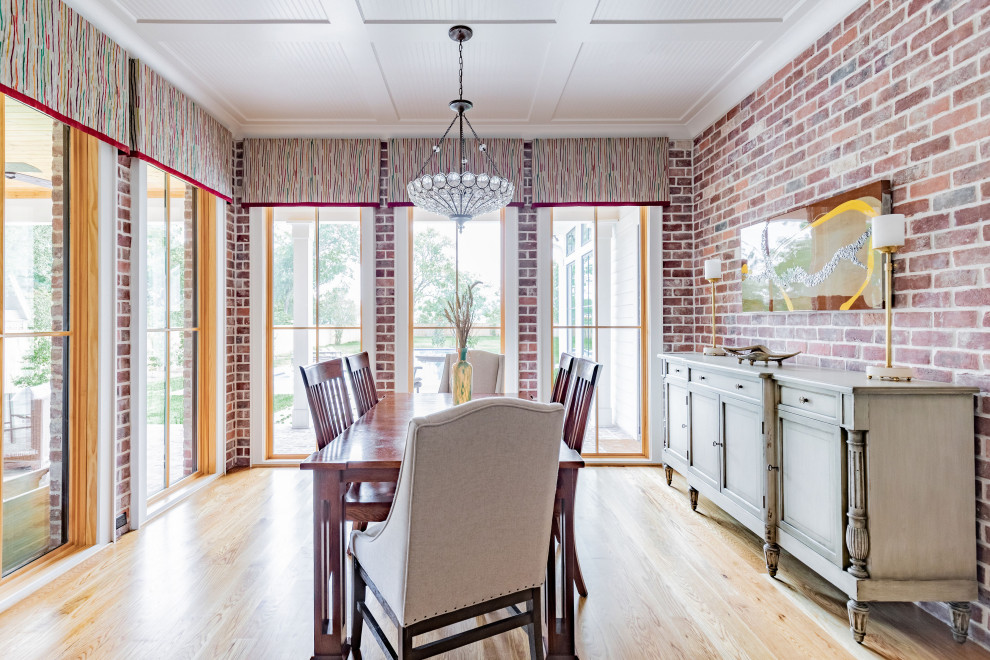Immagine di una grande sala da pranzo country chiusa con pareti rosse, parquet chiaro e pavimento beige