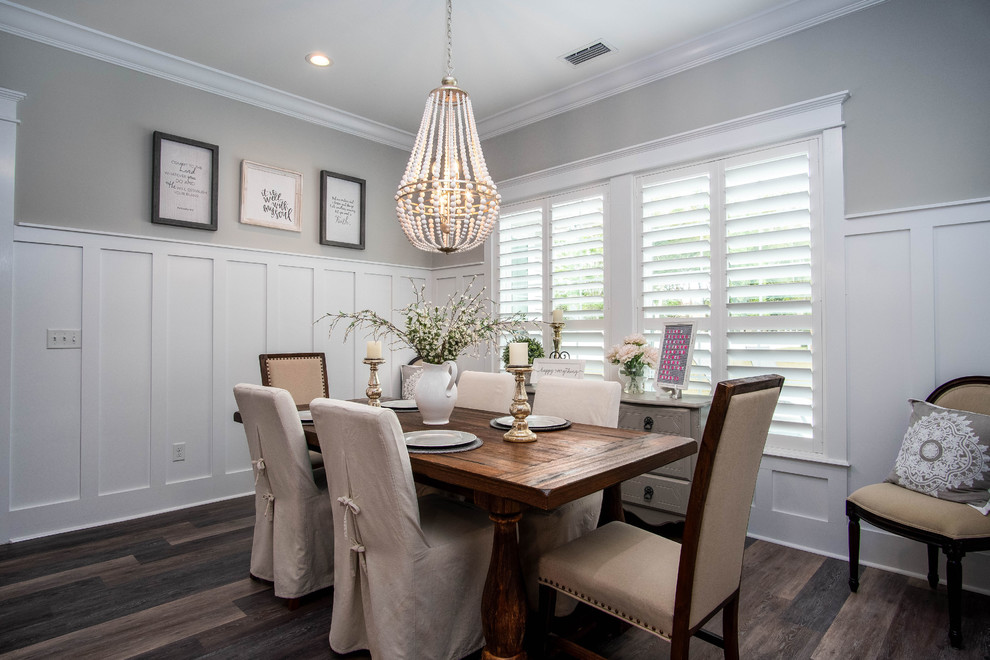 Inspiration for a large farmhouse vinyl floor and brown floor enclosed dining room remodel in Jacksonville with gray walls