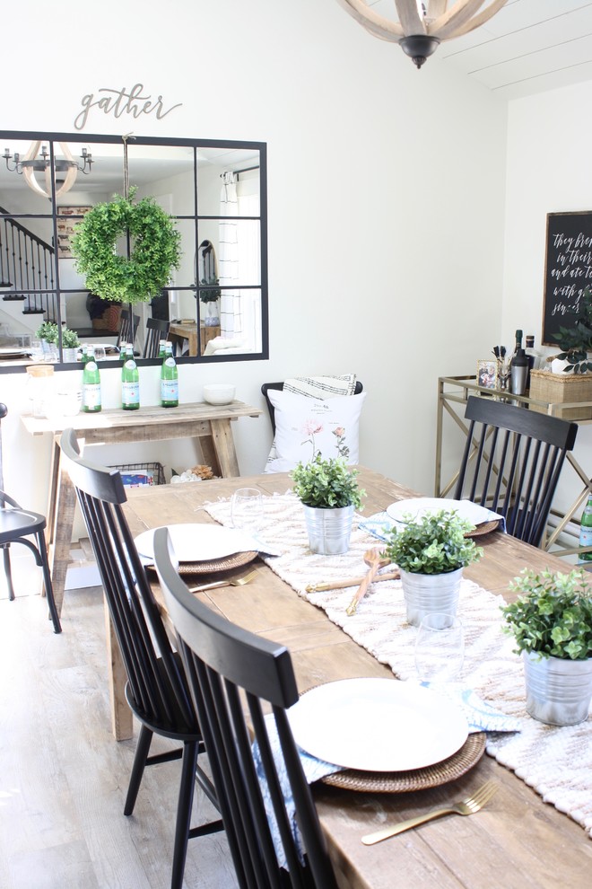 Immagine di una sala da pranzo aperta verso la cucina country di medie dimensioni con pareti bianche, pavimento in vinile, nessun camino e pavimento marrone