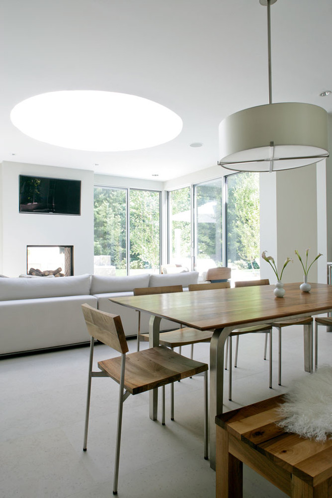 Foto di una sala da pranzo aperta verso il soggiorno minimal di medie dimensioni con pareti bianche, moquette e nessun camino