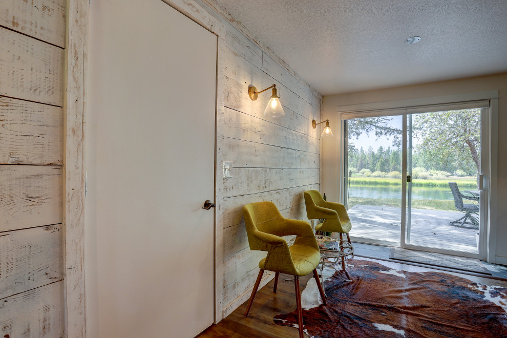 Esempio di una sala da pranzo aperta verso il soggiorno stile rurale di medie dimensioni con pareti bianche, pavimento in laminato e pavimento marrone